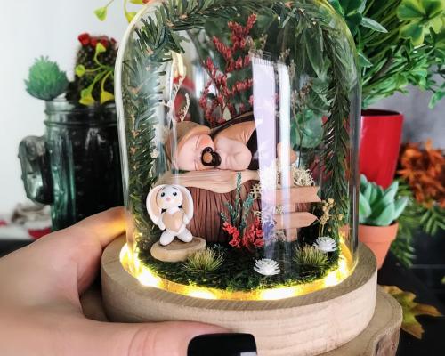 Cloche LED enchantée en dôme de verre avec un bébé petit garçon sculpté à la main dans un jardin miniature personnalisé avec les éléments de naissance