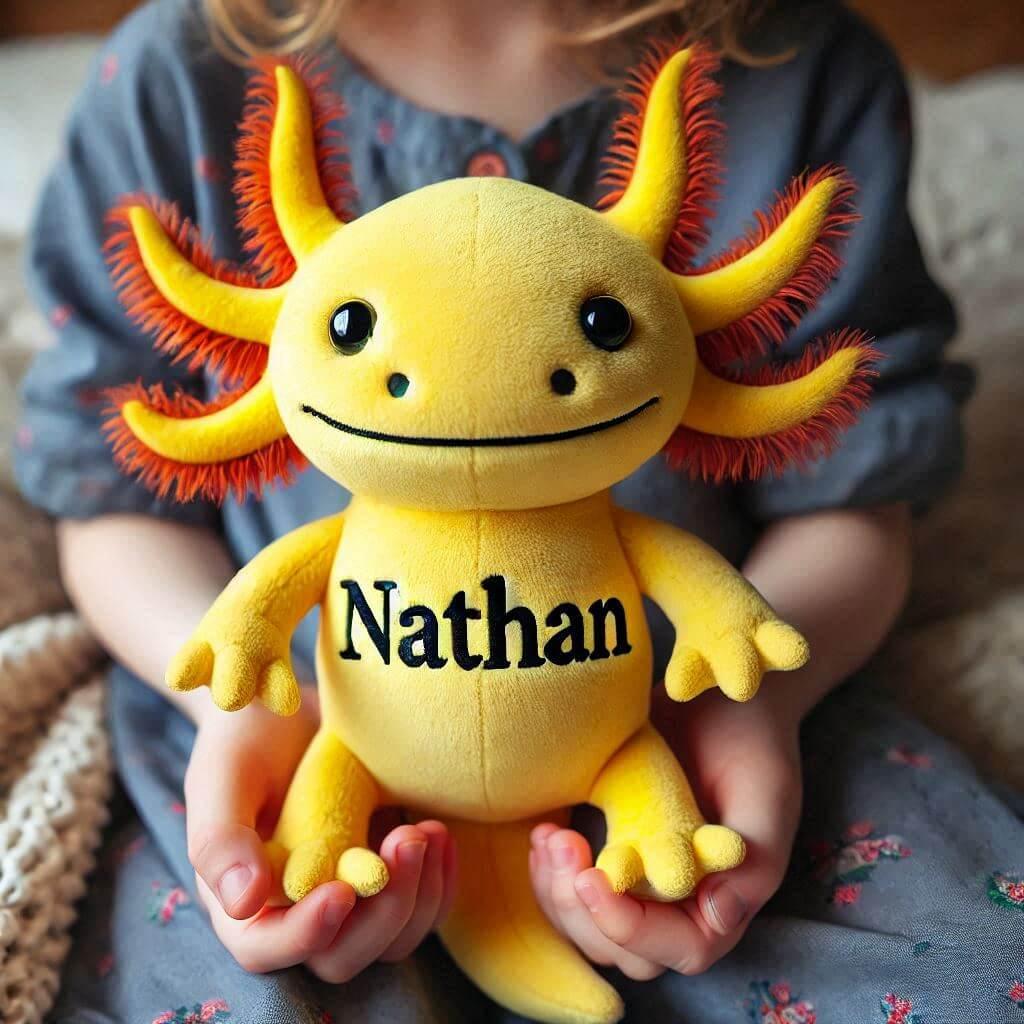 Peluche axolotl jaune personnalise avec le prenom nathan dans les mains d un enfant