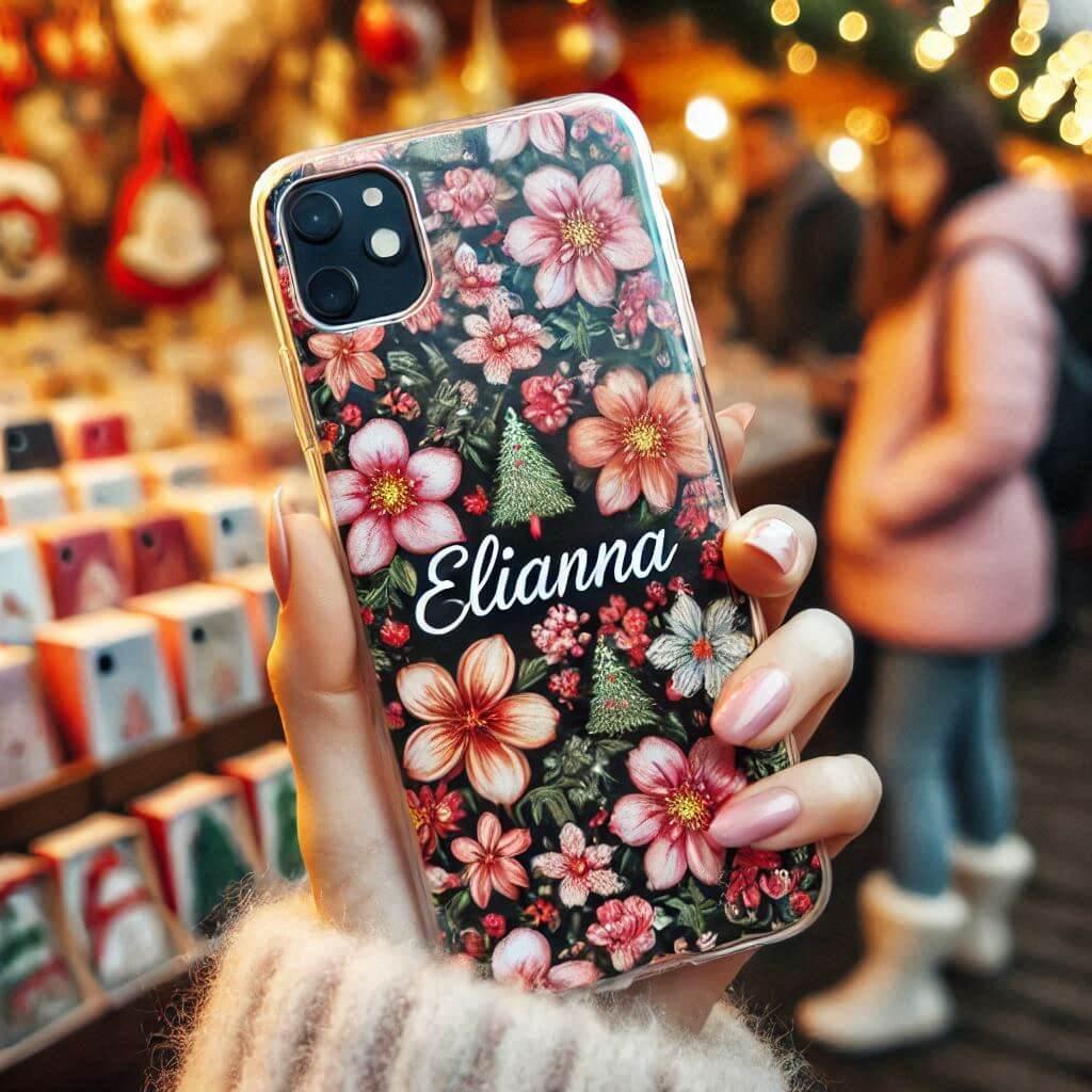 Une coque de telephone fleuri avec ecrit elianna dans les mains dune femme au marche de noel